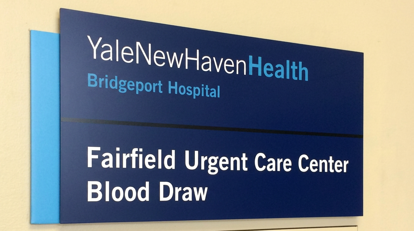 Wall-mounted navy room identification sign for a hospital urgent care center blood draw suite