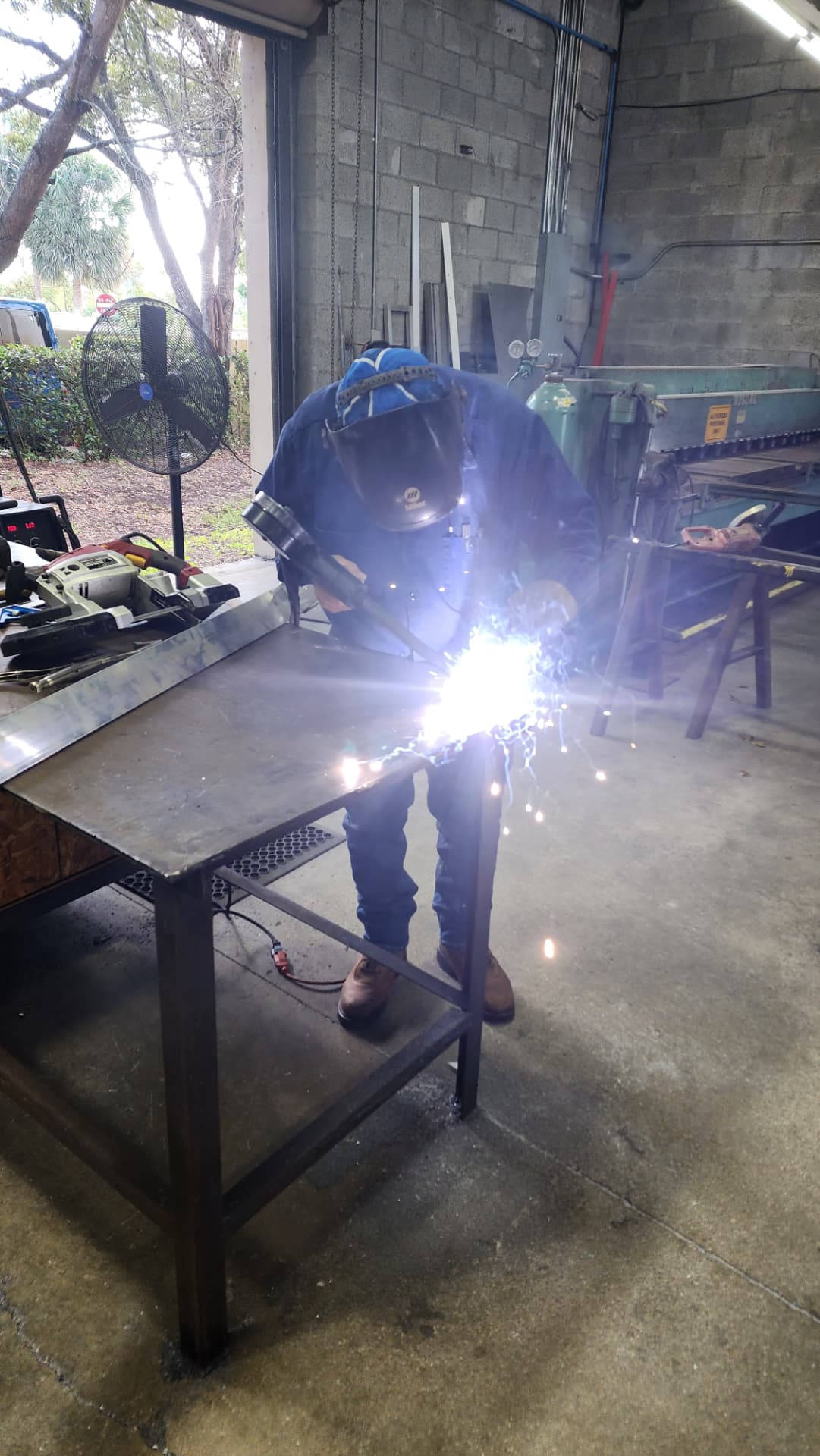 AIS fabricator welding a metal sign frame in the AIS shop