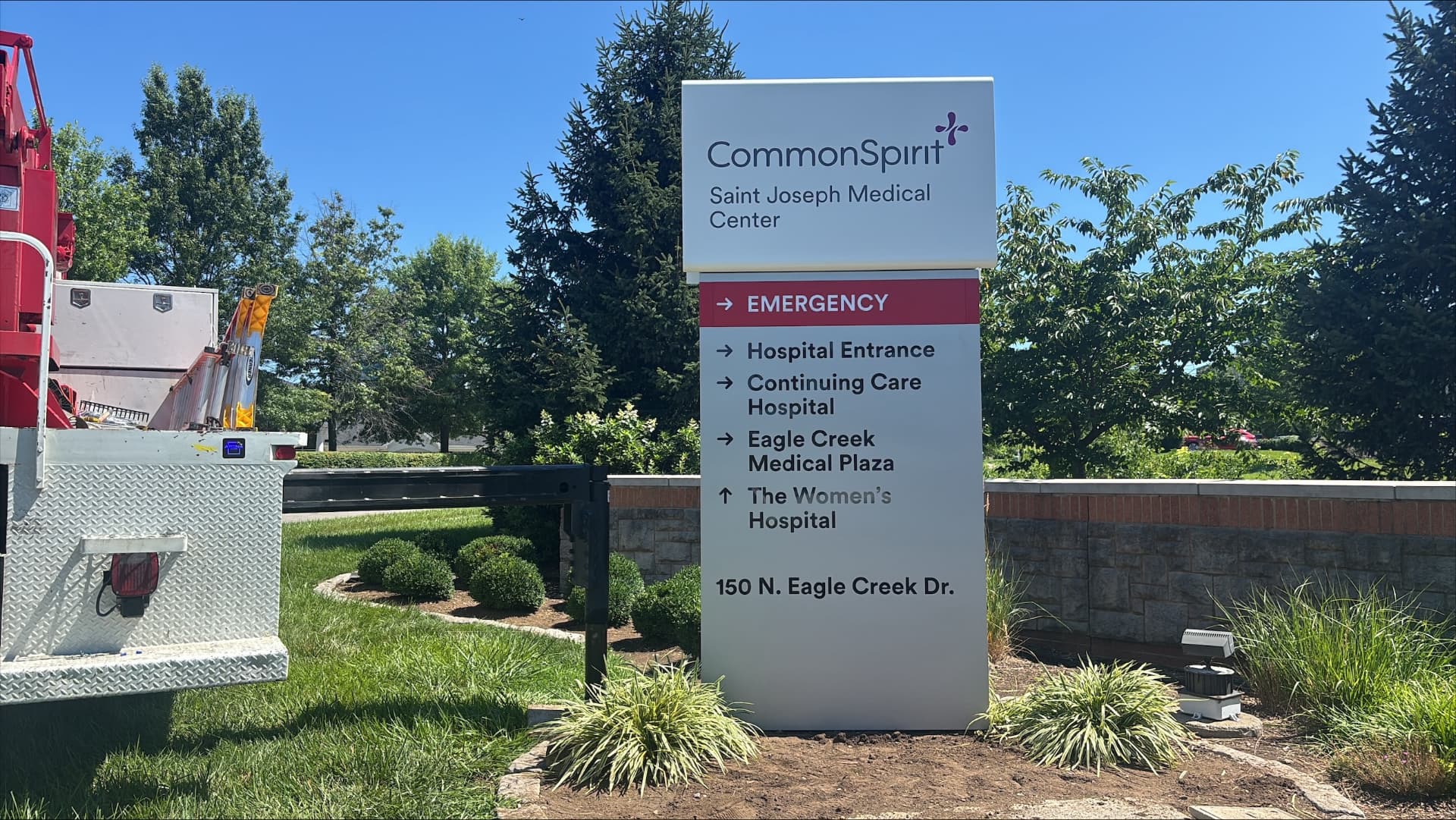 CommonSpirit Saint Joseph Medical Center directional monument sign with AIS bucket truck alongside