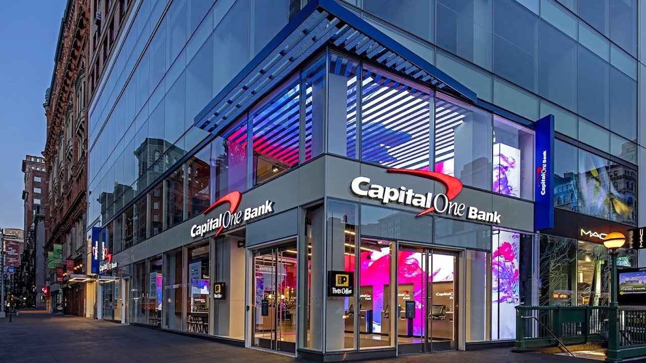 Capital One Bank corner branch with illuminated channel letters and integrated digital branding at dusk.