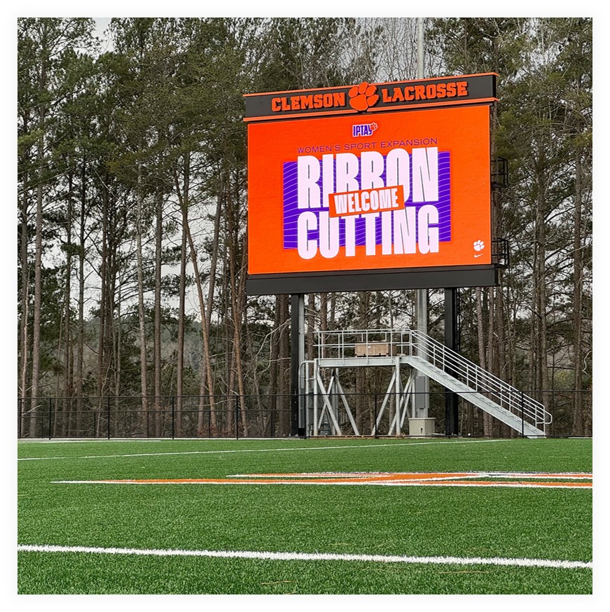 Clemson Lacrosse LED video display on a steel structure at the edge of a turf field