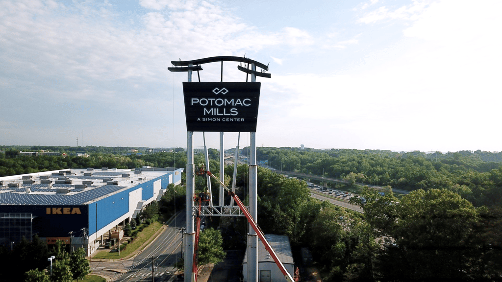 Crane installing the Potomac Mills pylon sign during an active AIS installation